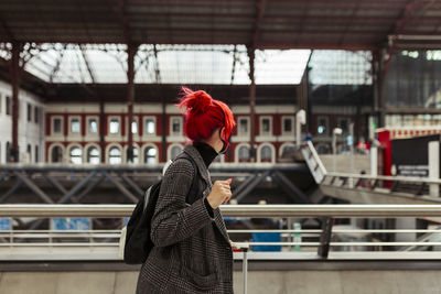 Side view of woman standing by railing in city