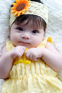 Close-up portrait of cute baby girl lying down