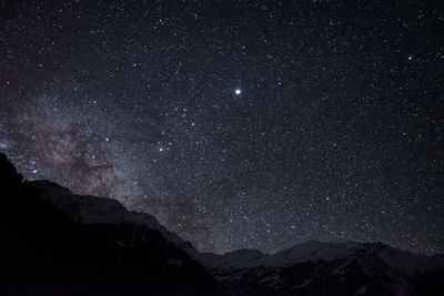 Scenic view of silhouette mountains against sky at night