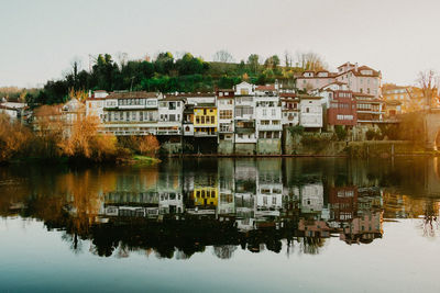 Buildings by lake against sky