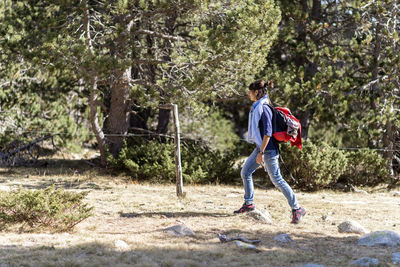 Full length of man running on road in forest