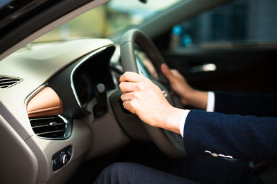 Cropped image of businessman driving car