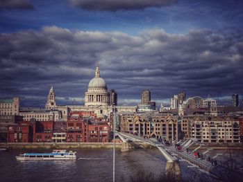 Buildings in city against cloudy sky