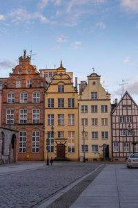 Residential buildings by street against sky