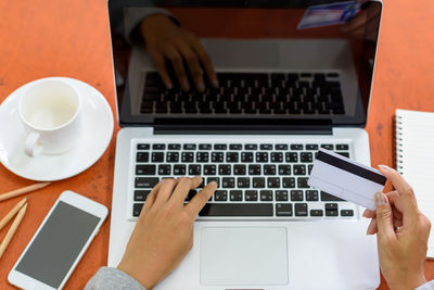 Midsection of man using laptop on table