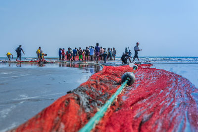 People on beach against clear sky