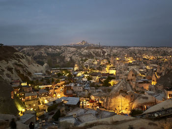 Cave houses and volcanic landscape of cappadocian town goreme and uchisar castle at the horizon