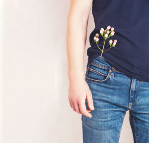 A man in a t-shirt with a flower in his jeans pocket. health,wellness and environmental care concept