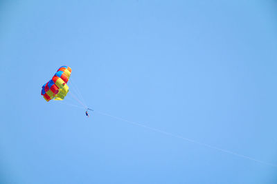 Low angle view of kite flying against clear blue sky