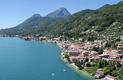 Aerial view of townscape by lake garda against sky