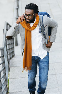 Man talking on mobile phone while walking in city