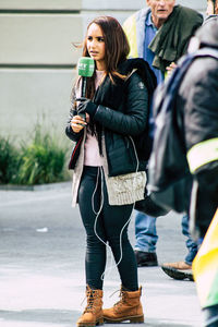 Full length of woman holding umbrella while standing on street