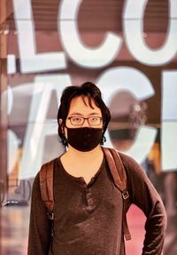 Portrait of woman standing against wall