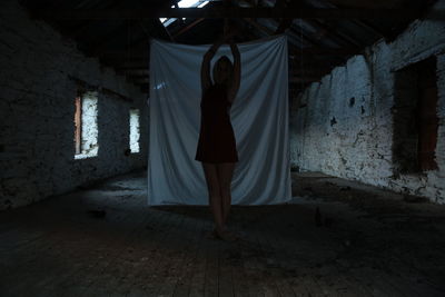 Rear view of woman standing in corridor of abandoned building