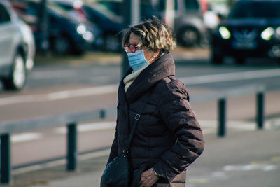 Portrait of woman standing on road in city