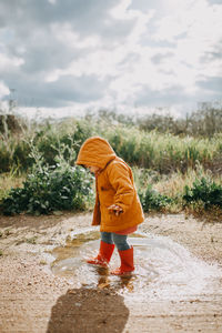 Side view of a boy standing on water