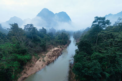 Scenic view of trees and mountains against sky