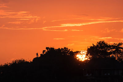 Silhouette trees against romantic sky at sunset