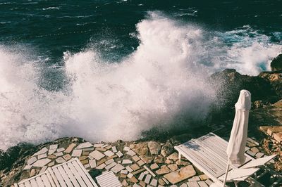 High angle view of wave splashing on rocks