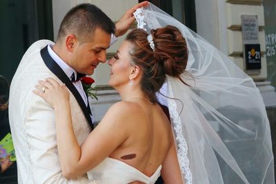 Bride and groom embracing in room