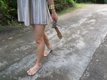 Low section of woman walking in water