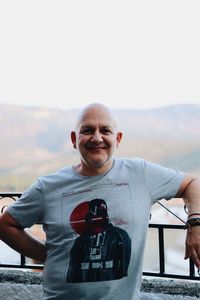 Portrait of smiling man standing against sky