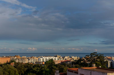 High angle view of townscape by sea against sky