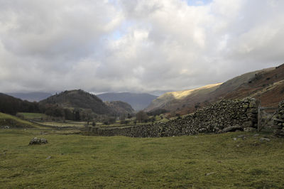 Scenic view of field and mountains against sky