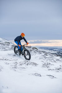 Man cycling in winter landscape