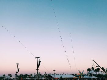 Low angle view of birds flying against clear sky