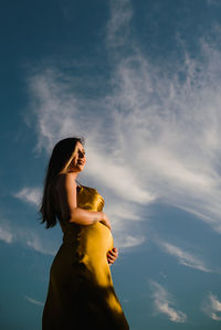 Low angle view of woman standing against sky