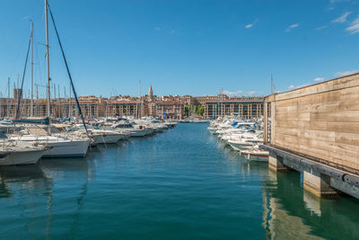 Sailboats moored in harbor