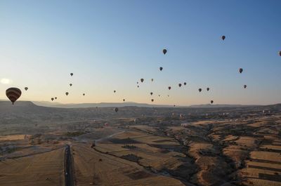 Aerial view of hot air balloons over vast landscape