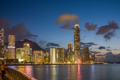 Illuminated buildings in city against sky at night