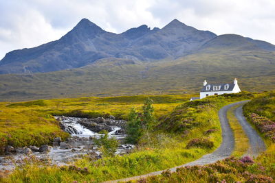 Road leading towards mountains against sky