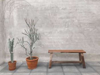 Empty bench on table against wall