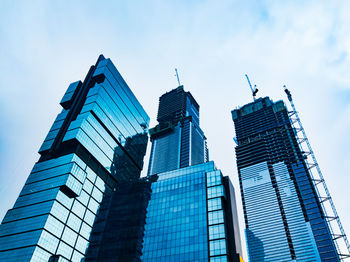 Low angle view of modern buildings against blue sky