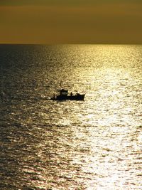 Boats in sea at sunset