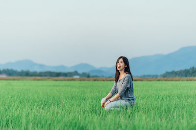 Full length of smiling woman on field