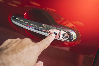 Close-up of hand holding red car