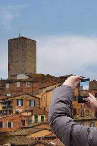 Person with mobile phone photographing panorama of siena person