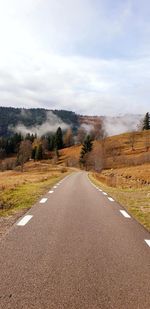 Road amidst trees against sky