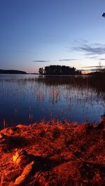 Scenic view of lake against sky at sunset