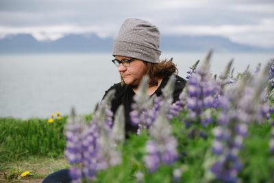 Woman standing on field with purple flowers