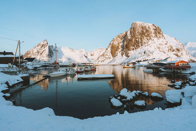 Scenic view of lake by snowcapped mountains against sky