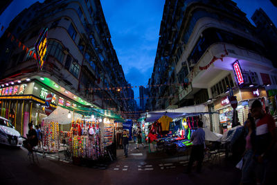 People at illuminated market in city at night