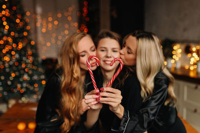 Happy funny girls celebrate christmas holidays and new year in a cozy house