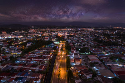 High angle view of illuminated city against sky at night