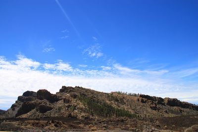 Rock formations on landscape against blue sky