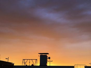 Low angle view of silhouette building against sky during sunset